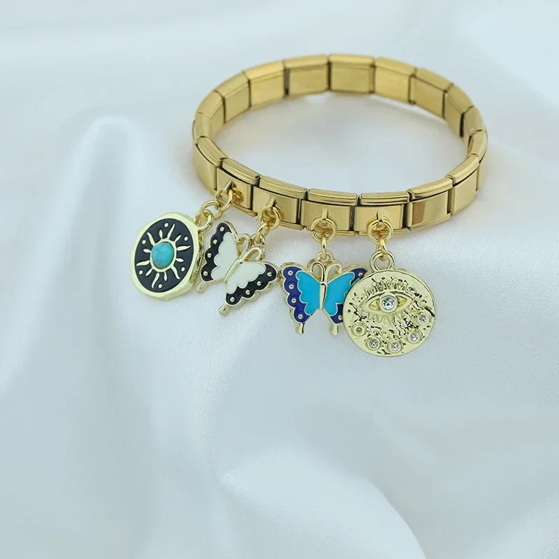 Butterfly Heart Eye golden charms – gold Italian charm bracelet with eye disc and butterfly charms displayed on fabric, Italian charm bracelet lifestyle photo by Charmtastic