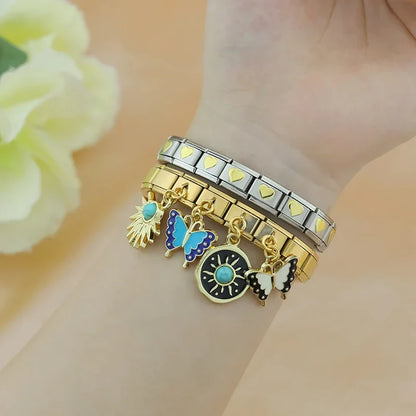 Butterfly Heart Eye golden charms – gold Italian charm bracelet with sunburst and butterfly charms worn on wrist, Italian charm bracelet lifestyle photo by Charmtastic