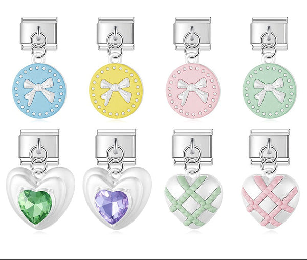 A 9mm Italian charm featuring a coquette-inspired dangle. Available in pastel enamel bow coins, quilted puffy hearts, and puffy hearts with a large crystal gem.