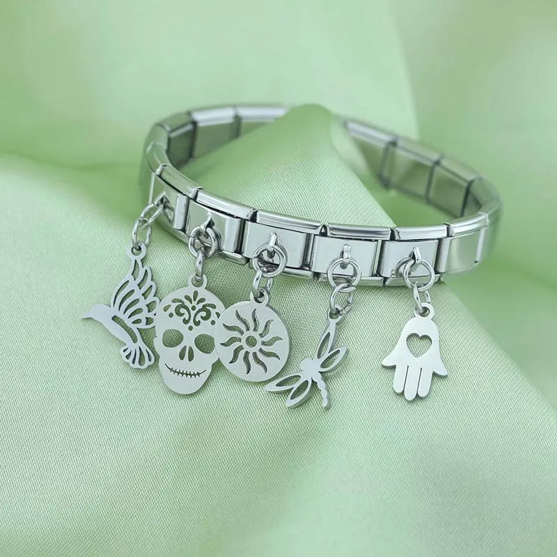 Hand Sun Skull Birds Star Heart silver charms – assorted silver charms including skull, sun, dragonfly, and hamsa hand on a stainless steel Italian charm bracelet, styled photo by Charmtastic