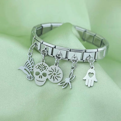 Hand Sun Skull Birds Star Heart silver charms – assorted silver charms including skull, sun, dragonfly, and hamsa hand on a stainless steel Italian charm bracelet, styled photo by Charmtastic
