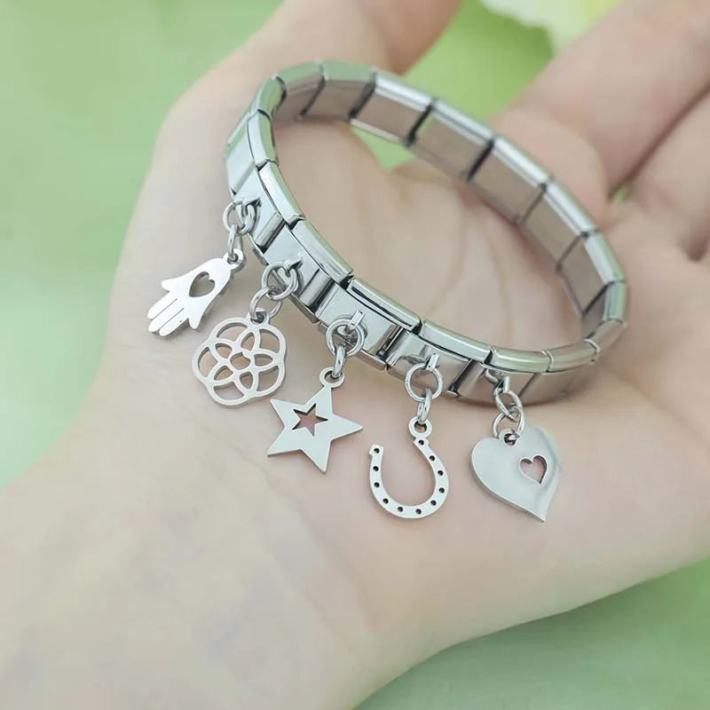 Hand Sun Skull Birds Star Heart silver charms – assorted silver charms including hamsa hand, flower, star, horseshoe, and heart worn on a stainless steel Italian charm bracelet, lifestyle photo by Charmtastic