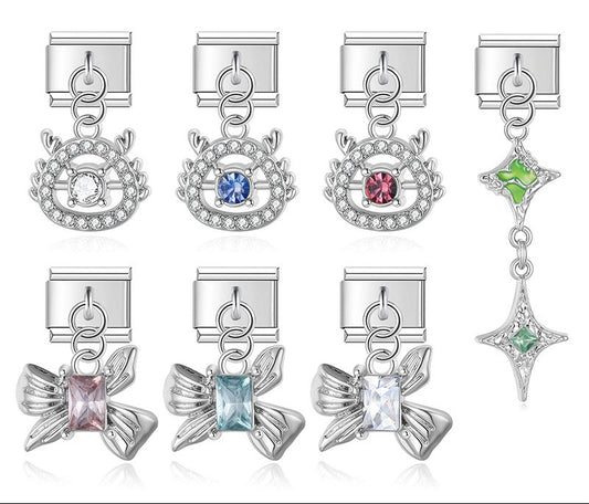 A collection of premium silver 9mm Italian charm dangles featuring rhinestone halos, sculpted metallic bows with rectangular gems, and a cascading green starburst.