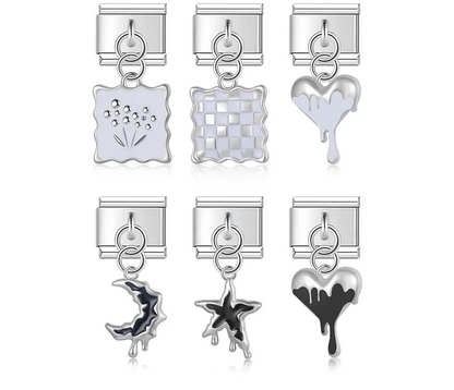 A collection of 9mm silver Italian charms featuring dripping enamel hearts, stars, and crescent moons in black and white, plus wavy-edged squares with floral and checkerboard patterns.