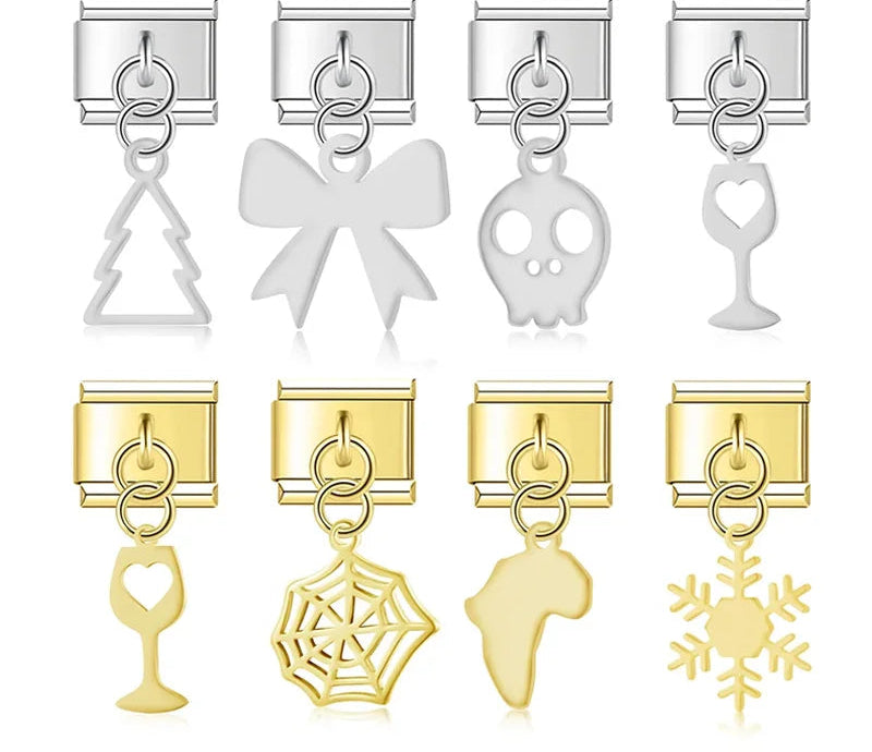 A collection of 9mm Italian charm dangles featuring sleek metal cutouts including a skull, bow, spider web, wine glass, snowflake, tree, and map of Africa in silver and gold.