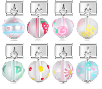 A collection of 9mm silver Italian charms featuring frosted glass bead dangles. Hand-painted designs include strawberries, florals, polka dots, stripes, and swirls.