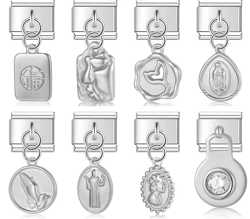 A collection of 9mm silver Italian charms featuring deeply sculpted dangles. Includes religious medals, a vintage cameo portrait, a crystal solitaire, an abstract face, a whale tail, and a good fortune tag.