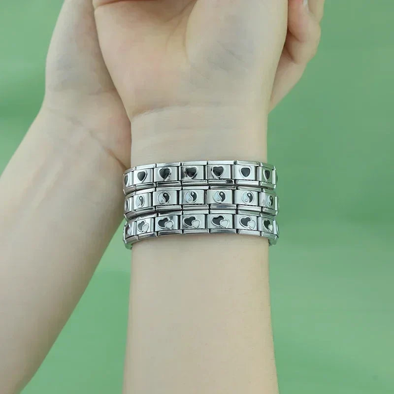 Silver charms bracelets with black designs – black heart and yin-yang Italian charm bracelets worn on wrist, by Charmtastic