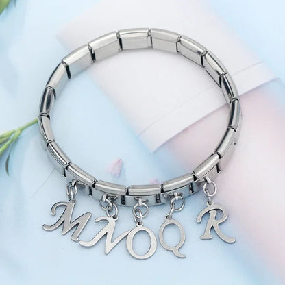 silver letters dangle charms – silver script letter charms spelling MNOQR worn on a stainless steel Italian charm bracelet, lifestyle photo by Charmtastic