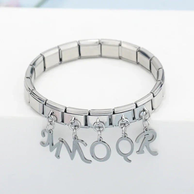 silver letters dangle charms – silver script letter charms spelling MMOQR worn on a stainless steel Italian charm bracelet, close lifestyle photo by Charmtastic