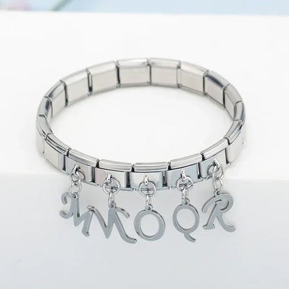silver letters dangle charms – silver script letter charms spelling MMOQR worn on a stainless steel Italian charm bracelet, close lifestyle photo by Charmtastic